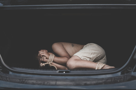 The kidnapped kid is tied to the back of the ca, Little boy with rope tied legs and hands in car, children thief, Criminal stealing child in human child traficking concept,の写真素材