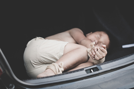 Little boy with rope tied legs and hands in car, children thief, Criminal stealing child in human child traficking concept,の写真素材