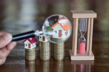 Stack coin and bar graph with grow, magnifying glass searching for a new home, Loan for real estate or save money for buy a house to family in the future concept.の写真素材