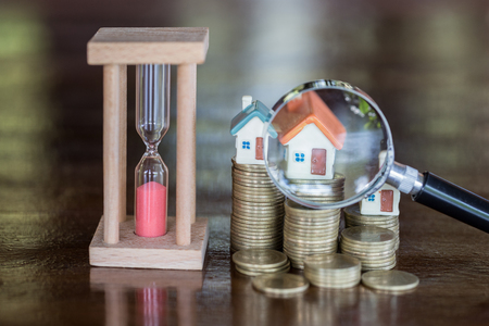 Stack coin and bar graph with grow,  magnifying glass searching for a new home, Loan for real estate or save money for buy a house to family in the future concept.の写真素材