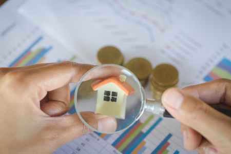 Stack coin and bar graph with grow, magnifying glass searching for a new home, Loan for real estate or save money for buy a house to family in the future concept.の写真素材