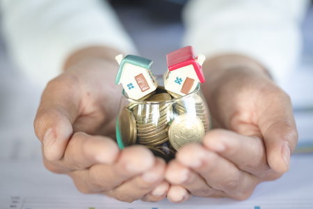 House models and coin in human hands, Mortgage concept by money house from the coins.の写真素材