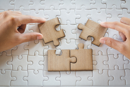Closeup hand of man connecting jigsaw puzzle with sunlight effect, Business solutions, success and strategy conceptの写真素材