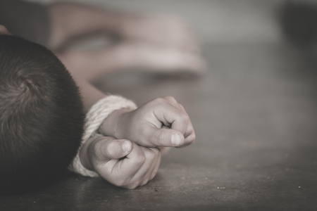 The child is bound by a rope, Stop Child Violence and Trafficking. Stop Violence Against Children, child bondage, Human Rights Day concept.の写真素材