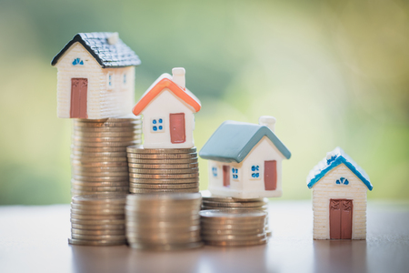 Mini house on stack of coins,Money and house,  Mortgage, Savings money for buy house and loan to business investment for real estate concept. Invesment and Risk Management, hourglass.の写真素材