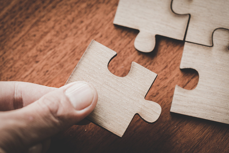 Hand put the last piece of jigsaw puzzle to complete the mission, Business solutions, success and strategy conceptの写真素材