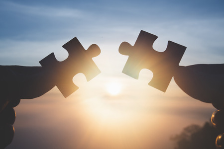 Silhouette Woman hands connecting couple jigsaw puzzle piece against sunrise, Business solutions, target, success, goals and strategy conceptsの写真素材