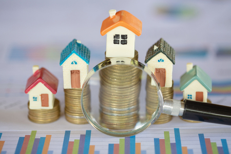 Stack coin and bar graph with grow,  magnifying glass searching for a new home, Loan for real estate or save money for buy a house to family in the future concept.の写真素材