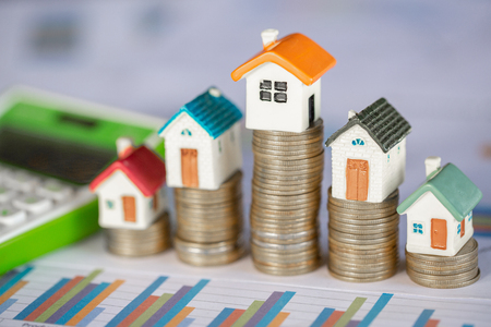 Mini house on stack of coins,Money and house,  Mortgage, Savings money for buy house and loan to business investment for real estate concept. Invesment and Risk Management.の写真素材