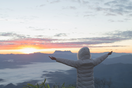 Christian woman  hands praying to god on the mountain background with morning sunrise. Woman Pray for god blessing to wishing have a better life. Christian life crisis prayer to god.の写真素材