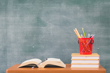 School books on desk, Back to school supplies. Books and blackboard on wooden background, education conceptの写真素材