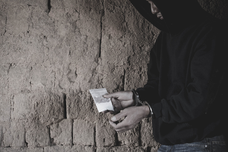 Drug dealer under arrest confined with handcuffs along with heroin,  Law and police concept.  World Anti-drug Dayの写真素材