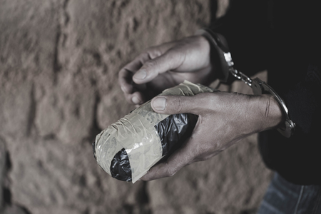 Drug dealer under arrest confined with handcuffs along with heroin,  Law and police concept.  World Anti-drug Dayの写真素材