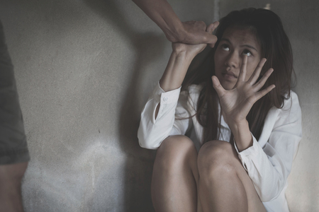 Domestic violence with a man hurting to a terrified woman  in a dark place, stop domestic violence against women の写真素材