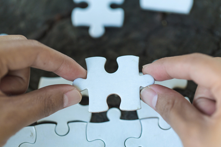 Jigsaw puzzle in the hand of a businessman,  Business team assembling Jigsaw puzzle.の写真素材