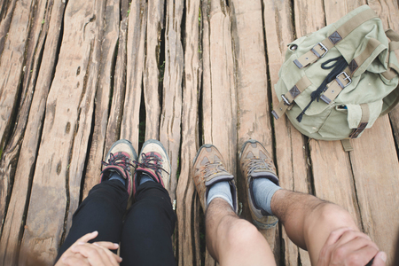 Group of man and women are walking trough forest path wearing mountain boots and walking sticks. Low section view.の写真素材