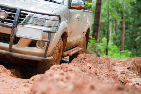 Dirty offroad car, SUV covered with mud on countryside road, Off-road tires,  offroad travel  and driving concept.の写真素材