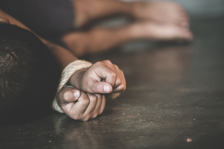 Victim boy with hands tied up with rope in emotional stress and pain,  kidnapped, abused, hostage,  Stop abusing violence, Children violence and abused conceptの写真素材