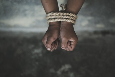 Victim boy with hands tied up with rope in emotional stress and pain,  kidnapped, abused, hostage,  Stop abusing violence, Children violence and abused conceptの写真素材