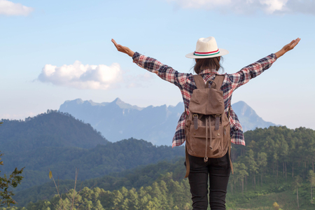 Freedom traveler woman standing with raised arms and enjoying a beautiful nature.の写真素材