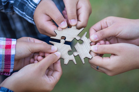people helping in assembling puzzle, cooperation in decision making, team support in solving...