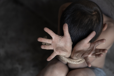 Child abuse, victim boy with hands tied up with rope in emotional stress and pain, Violent acts against children, Missing, Children kidnapped and abusedHuman trafficking.の写真素材