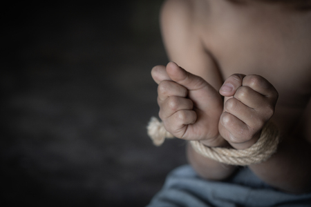 Child abuse, victim boy with hands tied up with rope in emotional stress and pain, Violent acts against children, Missing, Children kidnapped and abusedHuman trafficking.の写真素材