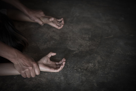 Man's hands holding a woman's hands for rape and sexual abuse,  Hands for rape and sexual abuse concept, Sexual abuse is a problem or Social issues concept.の写真素材
