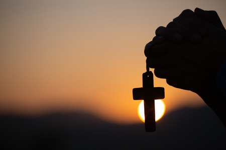 Christian woman praying on holy cross in the morning, teenager woman hand with cross praying,Hands folded in prayer in church concept for faith, spirituality and religionの写真素材