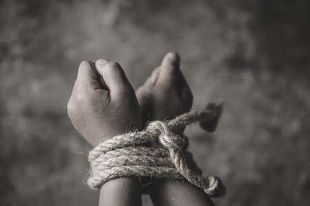 hopeless child hands tied together with rope, human trafficking, Stop abusing violence.