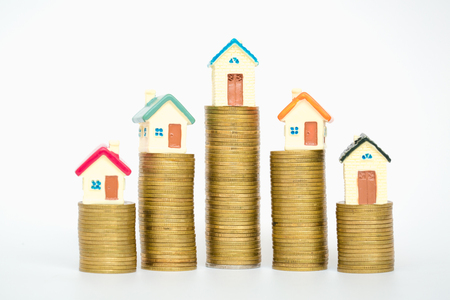 Mini house on stack of coins isolated on white background, Real estate investment, Save money with stack coin, Business growth investment and financial, Mortgage conceptの写真素材
