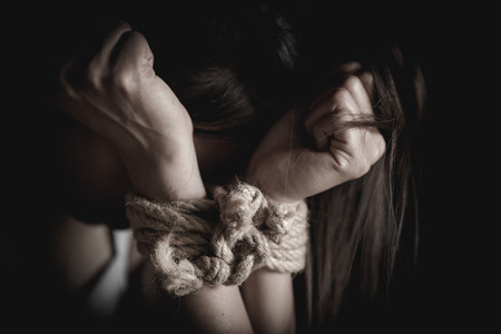The slave woman is tied with a rope, stop acts of violence against women, rape and sexual abuse, human trafficking,の写真素材