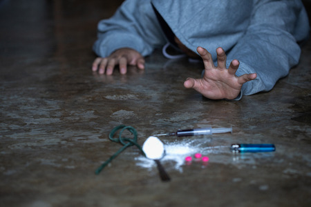 human hand trying to reach,  on  concrete floor. Drugs addiction and withdrawal symptoms concept. drugsInternational Day against Drug Abuse.の写真素材