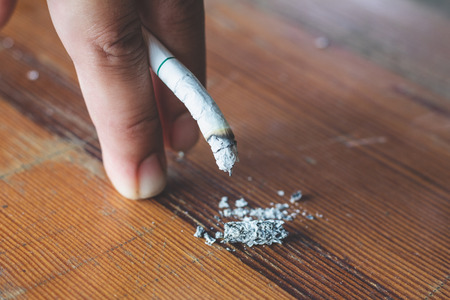 Man hand with burning cigarette as penis in smoking cause sexual erectile dysfunction,  tobacco causes to Erectile dysfunctionの写真素材