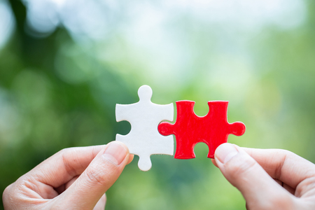 Close up of hands business women connecting jigsaw puzzle, Business Success,  Teamwork workplace success and strategy concept.の写真素材