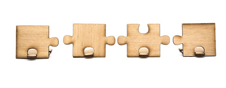pieces of wooden jigsaw are connected together isolated on white background. concept of connectingの写真素材