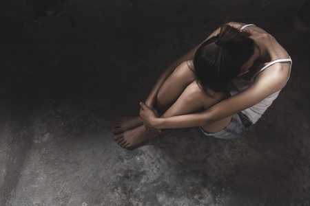 Sad and lonely girl crying with a hand covering her face. Stressed And Depressed Girl Touching Her Head,  Work Failure Concept. Copy space.の写真素材