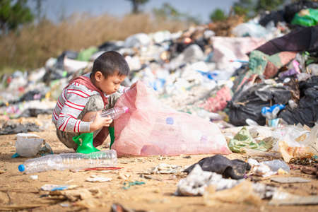 environment Earth Day, Child sitting to separate garbage to be recycled. The concept helps reduce air pollution and protect the environment.の写真素材