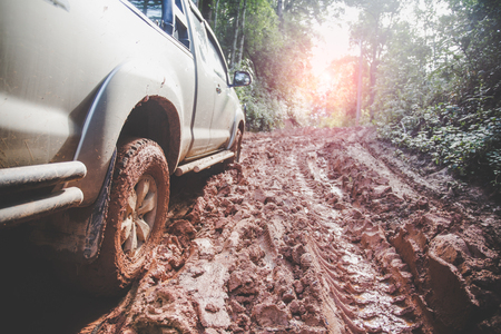 Dirty offroad car, SUV covered with mud on countryside road, Off-road tires,  offroad travel  and driving concept.の写真素材