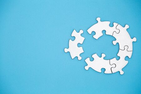 Unfinished white jigsaw puzzle pieces on blue background, The last piece of jigsaw puzzle, Copy...