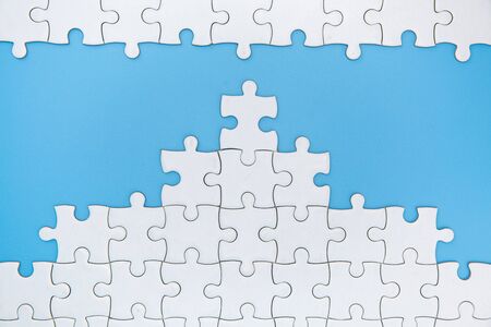 Unfinished white jigsaw puzzle pieces on blue background, The last piece of jigsaw puzzle, Copy...