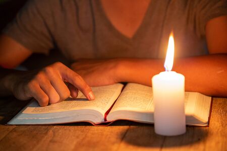close up of Christian boys  are reading and study bible In the room and lit candles to light, Religious conceptsの写真素材