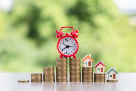 Mini house on stack of coins,Money and house,  Mortgage, Savings money for buy house and loan to business investment for real estate concept. Invesment and Risk Management, hourglass.の写真素材