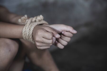Child abuse, victim boy with hands tied up with rope in emotional stress and pain, Violent acts...