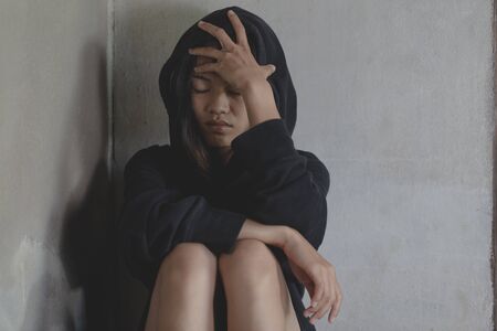 Depressed and hopeless teenage girl sitting alone after using drugs, Drugs addiction and withdrawal symptoms ,  No to drugs concept. International Day against Drug Abuse.の写真素材