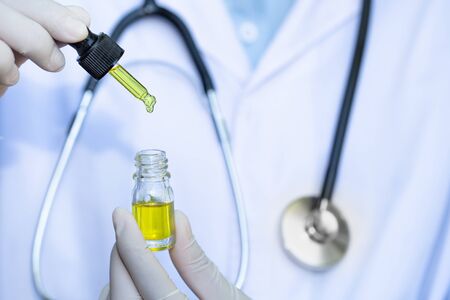 Doctor hand hold cannabis oil, Research of hemp oil extracts for medical purposesの写真素材
