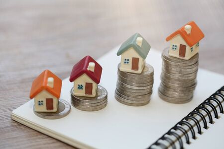 Mini house on stack of coins,Money and house,  Mortgage, Savings money for buy house and loan to business investment for real estate concept. Investment and Risk Management.の写真素材