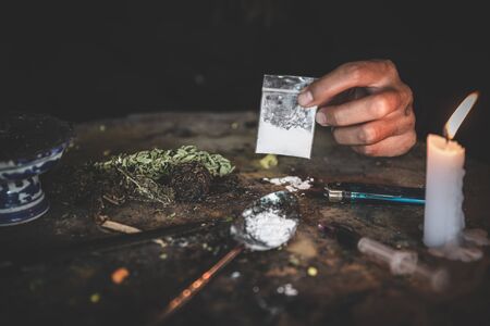 Hand of addict man holding cocaine or heroine, close up of addict buying dose from drug dealer, drug trafficking, crime, addiction and sale concept,の写真素材
