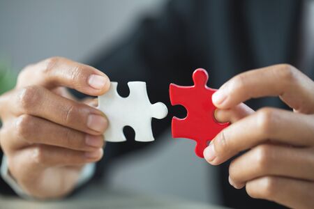 Businessman hand connecting jigsaw puzzle, Business solutions,  target, success, goals and strategy conceptsの写真素材