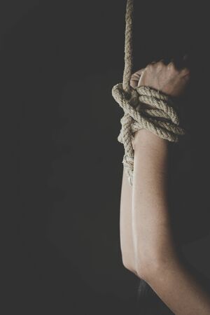 Hands of a missing kidnapped,  victim woman tied up with rope,Slavery, Human trafficking.の写真素材